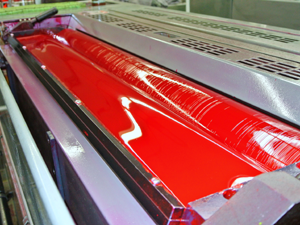 Red ink on the rollers of a printing press